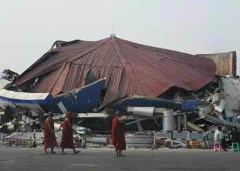 Buddhist monks walk past a collapsed building in Naypyitaw, Myanmar, after a powerful earthquake, March 29, 2025. [Aung Shine Oo/AP Photo]